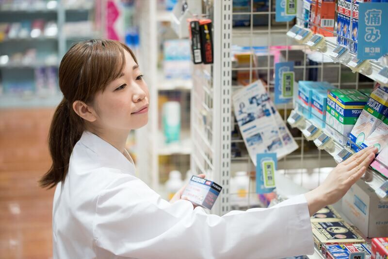 医薬品を陳列する女性スタッフ